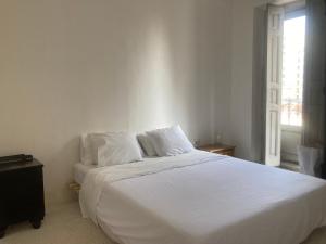 een wit bed in een slaapkamer met een raam bij Captivating 2-Bed Apartment in Madrid in Madrid