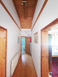 a hallway with white walls and a wooden ceiling at Cosy room in the nature in Graz