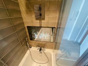 La salle de bains est pourvue de toilettes et d'un miroir mural. dans l'établissement Leigh On Sea - Prime Location! Ultra Modern Entire Apartment With Free Gated Parking & Private Balcony, à Southend-on-Sea