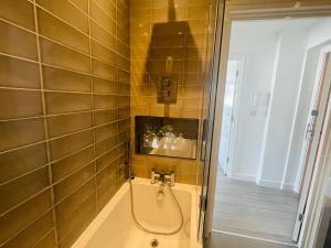 a bathroom with a shower and a bathtub with a hose at Leigh On Sea - Prime Location! Ultra Modern Entire Apartment With Free Gated Parking & Private Balcony in Southend-on-Sea