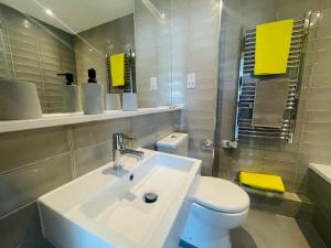 a bathroom with a white sink and a toilet at Leigh On Sea - Prime Location! Ultra Modern Entire Apartment With Free Gated Parking & Private Balcony in Southend-on-Sea