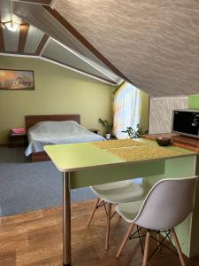 - une chambre avec un lit, une table et des chaises dans l'établissement Міні-готель, à Kotowsk