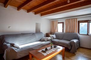 ein Wohnzimmer mit einem Sofa und einem Tisch in der Unterkunft Billy's Stonehouse in Samos