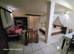 Habitación pequeña con 2 camas y sala de estar. en LA MARINA 1, en Ambodifototra