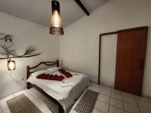 a bedroom with a bed with red pillows on it at Pousada Vila Gaia in Santo André