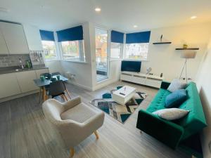 a living room with a green couch and a table at Leigh On Sea - Prime Location! Ultra Modern Entire Apartment With Free Gated Parking & Private Balcony in Southend-on-Sea