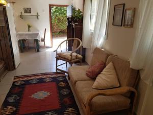uma sala de estar com um sofá e uma mesa em פינה מתוקה בעמק החולה em Yesud HaMa‘ala