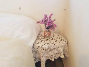 uma mesa com um vaso com flores roxas em פינה מתוקה בעמק החולה em Yesud HaMa‘ala