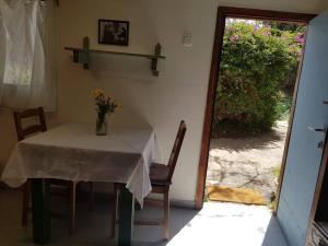 uma mesa e cadeiras com um vaso de flores em פינה מתוקה בעמק החולה em Yesud HaMa‘ala