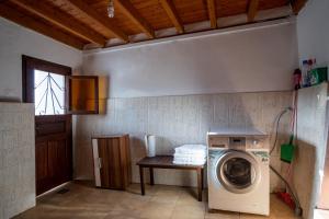 uma lavandaria com uma máquina de lavar roupa e uma mesa em Billy's Stonehouse em Samos