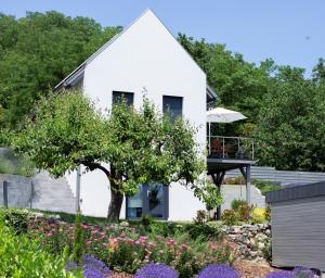 una casa blanca con un jardín delante de ella en P19 Boutique Villa Badacsony, en Badacsonytomaj