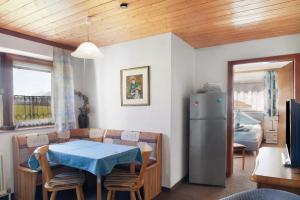 eine Küche und ein Esszimmer mit einem Tisch und einem Kühlschrank in der Unterkunft Fewo 3 Haus am Lärchenhang in Leutasch