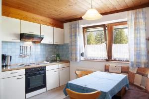 eine kleine Küche mit einem Tisch und einem Herd in der Unterkunft Fewo 3 Haus am Lärchenhang in Leutasch