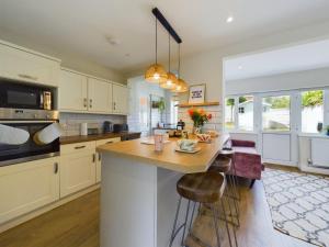 a kitchen with a large island with a wooden counter top at Stones Throw - stunning house, mins from beach and dogs welcome in Broadstairs