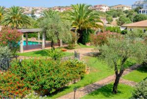 un jardín con árboles y flores y una piscina en Appartamento Le Palme Costa Smeralda, en Arzachena