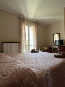 a large bed in a room with a window at Locanda 130 in Fonni