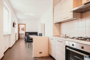 a kitchen with a refrigerator and a table with chairs at Appartamento Cairoli - Affitti Brevi Italia in Varese