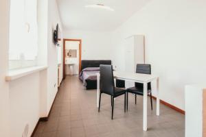 Cette chambre comprend une table, des chaises et un lit. dans l'établissement Appartamento Cairoli - Affitti Brevi Italia, à Varèse