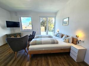 ein Schlafzimmer mit 2 Betten und einem Stuhl darin in der Unterkunft Ferienwohnung Sonnenaufgang in Sonthofen