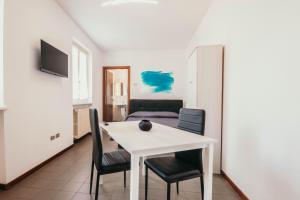 une salle à manger avec une table et des chaises blanches dans l'établissement Appartamento Cairoli - Affitti Brevi Italia, à Varèse