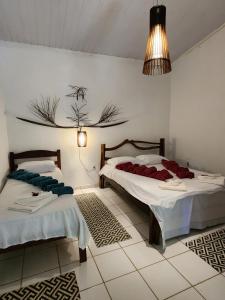 1 dormitorio con 2 camas y lámpara de araña en Pousada Vila Gaia, en Santo André