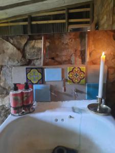 a bathroom with a candle and a bath tub at Kwaggaskop Farm Kliphuis in Dullstroom