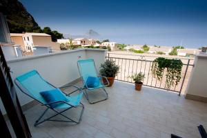 2 sedie sedute su un balcone con vista sull'oceano di Casa Turchese Unmarediblu a San Vito lo Capo