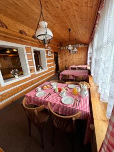 comedor con mesa y sillas en una cabaña en Penzion Bílá Labuť, en Pec pod Sněžkou