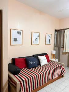 1 cama con almohadas rojas y blancas en una habitación en Dpto 2 AMB cerca de la playa en Santa Teresita en Santa Teresita