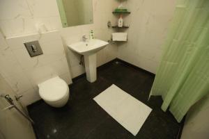 a bathroom with a white toilet and a sink at House Of Comfort Greater Noida Luxury in Greater Noida
