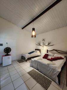 a bedroom with two beds and a rug at Pousada Vila Gaia in Santo André