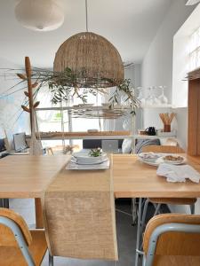 a dining room with wooden tables and a largeandelier at Ático en el mar in Alcossebre