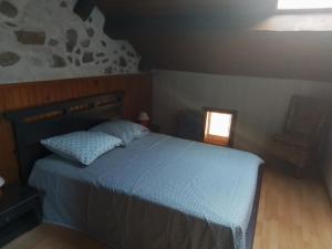 1 dormitorio con 1 cama con edredón azul y ventana en MAISON DE VILLAGE ST MARCELLIN en Veynes