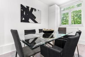 a dining room with a glass table and chairs at Finsbury Park Station Apartment! (B) in London