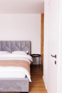 a bedroom with a large bed and a black table at Zenstay ApartHotel in Topliţa