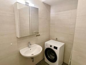 a bathroom with a sink and a washing machine at 75 m2 Stylish Apartment with Free Parking in Vienna