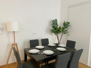 a black dining room table with chairs and a lamp at 75 m2 Stylish Apartment with Free Parking in Vienna