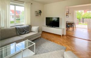 a living room with a couch and a flat screen tv at Nice Home In Bstad With Wifi And 3 Bedrooms in Båstad