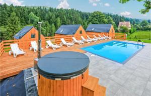 a deck with a pool and lounge chairs next to a house at Stunning Home In Slopnice With Wifi in Słopnice