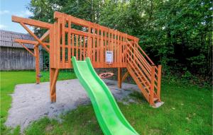 a wooden playground with a green slide in a yard at Stunning Home In Slopnice With Wifi in Słopnice