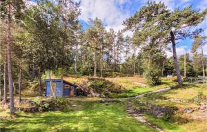 a small shed in a field with trees at Stunning Home In Trvikbygd With Kitchen in Tyrvikbygd