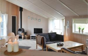 a living room with a couch and a table at Cozy Home In Hvide Sande With Kitchen in Havrvig
