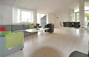 ヴィデ・サンデにあるHoliday Home Hvide Sande With A Fireplace 3のソファとテーブルと椅子のあるリビングルーム