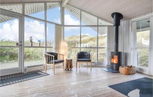 HalkærにあるBeautiful Home In Ringkbing With Wifiのリビングルーム(暖炉、椅子、窓付)