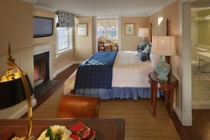 um quarto de hotel com uma cama e uma lareira em Inn on Boltwood em Amherst