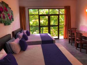 sypialnia z 2 łóżkami i dużym oknem w obiekcie Red Letter Hotel w mieście Kandy