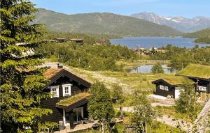 un groupe de maisons avec des toits en herbe et un lac dans l'établissement Lovely Home In Sykkylven With House A Panoramic View, à Sykkylven