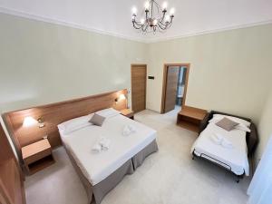 1 dormitorio con 2 camas y lámpara de araña en Il Pepe Affittacamere, en Bisceglie