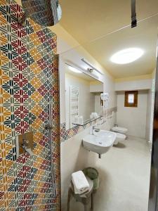 baño con 2 lavabos y una pared de mosaico en Il Pepe Affittacamere, en Bisceglie