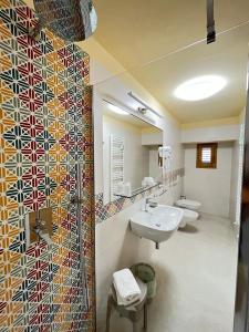 a bathroom with two sinks and a mosaic wall at Il Pepe Affittacamere in Bisceglie +11 photos